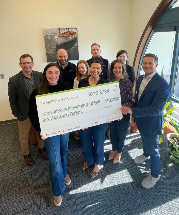 Group of people holding big check