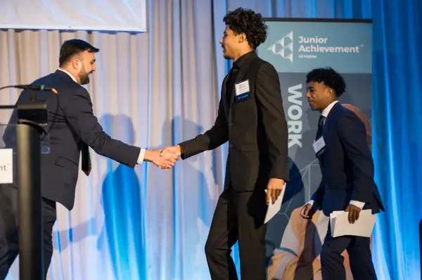 Students shaking a man's hand.