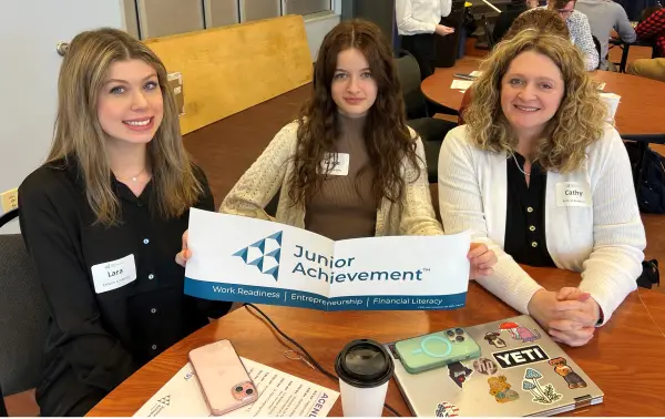 three women holding banner